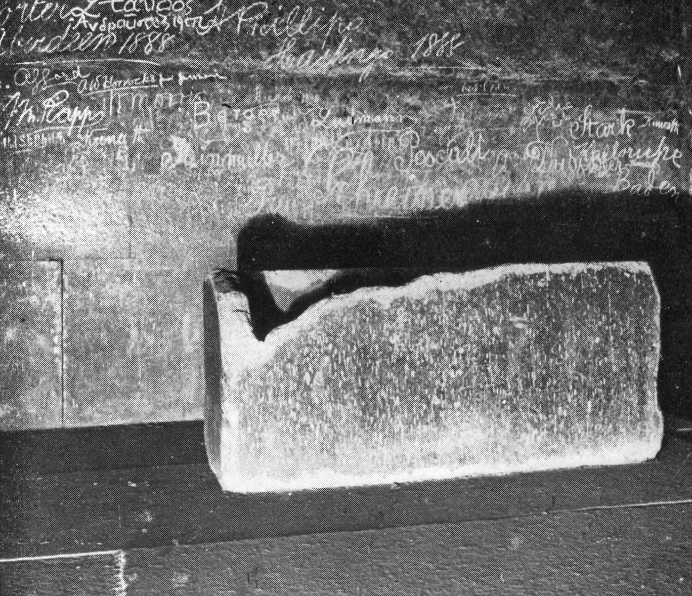 The granite box in the King's Chamber photographed around 1904: the top corner nearest the camera is broken away, and the wall behind is covered in scratched names