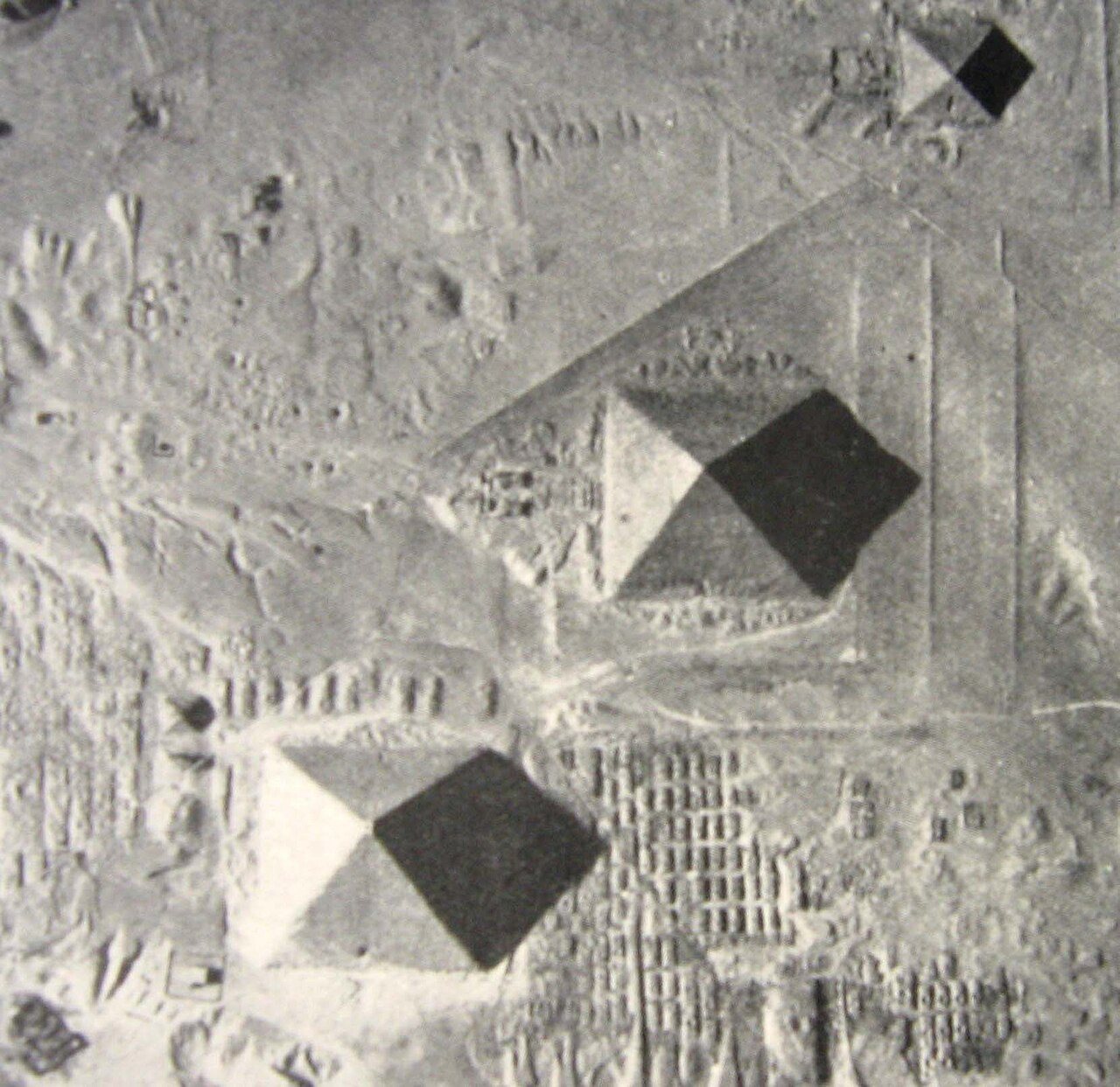 The 1926 aerial photograph of the Giza pyramids by P. R. C. Groves at an equinox: the north and south faces of the Great Pyramid each divided into a lit half and a shadowed half along their center lines
